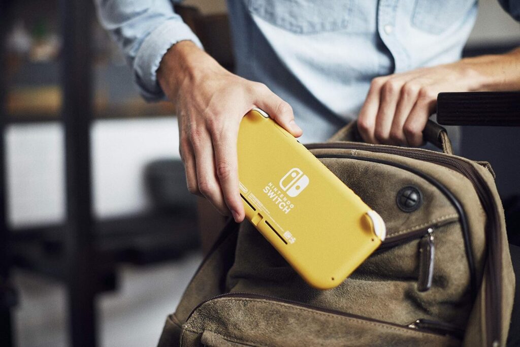 A man putting a Nintendo Switch Lite into his backpack.