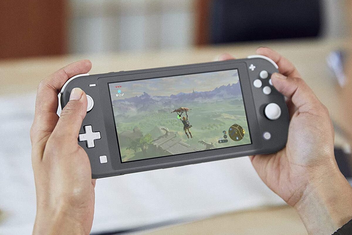 A person playing The Legend of Zelda: Breath of the Wild on a Nintendo Switch Lite.